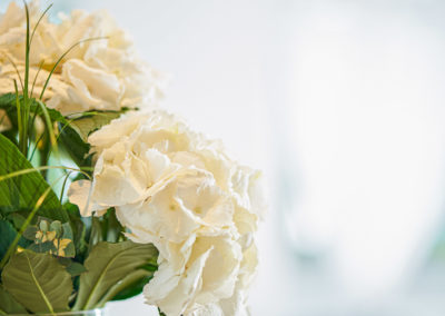 Weiße Blumen in einer Glasvase im Eingangsbereich | Apart Business Hotel